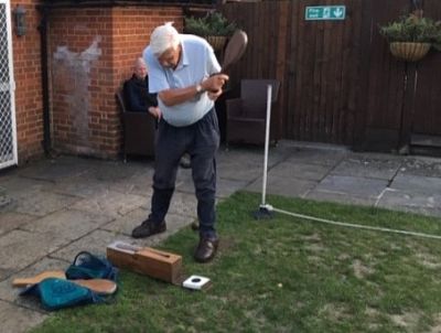 Past President David Barton takes a swing with his bat, looked on by Rtn Andrew Barchi. 