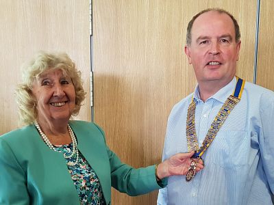 Incoming president Neil Fraser receives the presidential chain from outgoing president Dr Margaret Griffin.