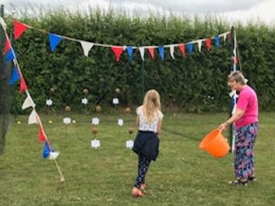 A youngster has a go on our coconut shy at the RDA fundraising event. 